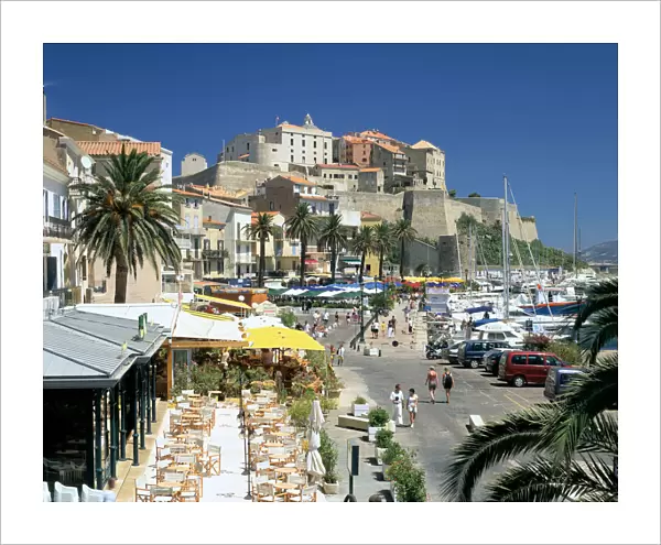 Restaurants in the old port with the Citadel in the background, Calvi, Corsica
