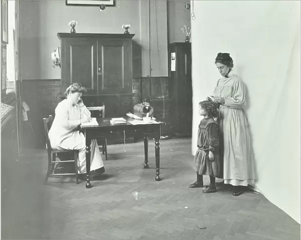 School nurse examining girls hair for head lice, Chaucer School, London, 1911