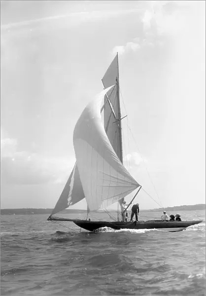 The 8 Metre Termagant sailing with spinnaker, 1911. Creator: Kirk & Sons of Cowes