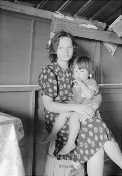 Mother with sick baby awaits arrival of FSA camp resident nurse, FSA camp, Tulare County, CA, 1939. Creator: Dorothea Lange