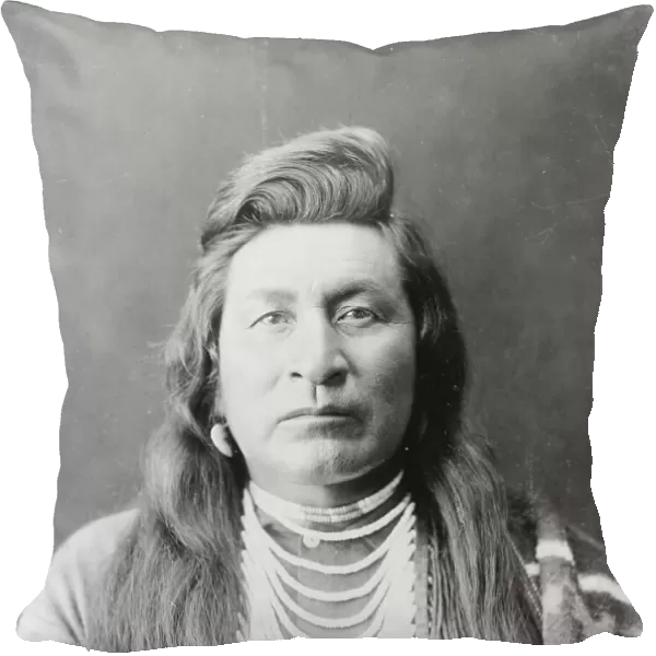 Nez Percé man, head-and-shoulders portrait, facing front, wearing bead necklace... c1899. Creator: Edward Sheriff Curtis
