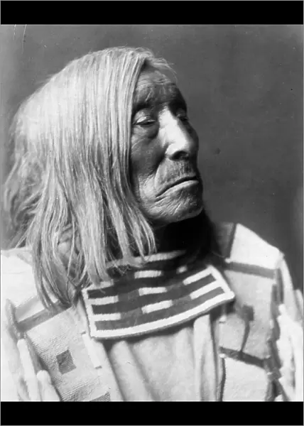 Lone Tree, an Apsaroke Indian, head-and-shoulders portrait, facing right, c1908. Creator: Edward Sheriff Curtis