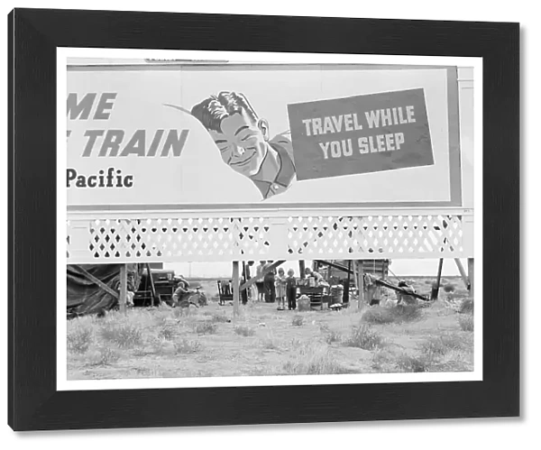 Billboard along U.S. 99 behind which three destitute families... Kern County, California, 1938. Creator: Dorothea Lange