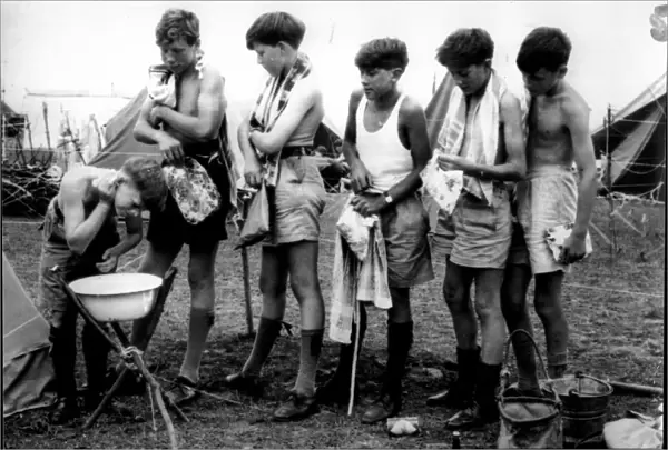 Boys scouts line up to wash in a bowl