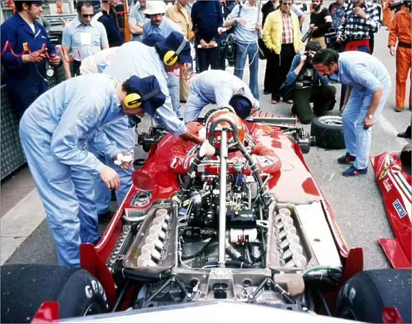 Formula One World Championship: Second placed Niki Lauda sits in his Ferrari 312T2 as mechanics prepare it for action during practice