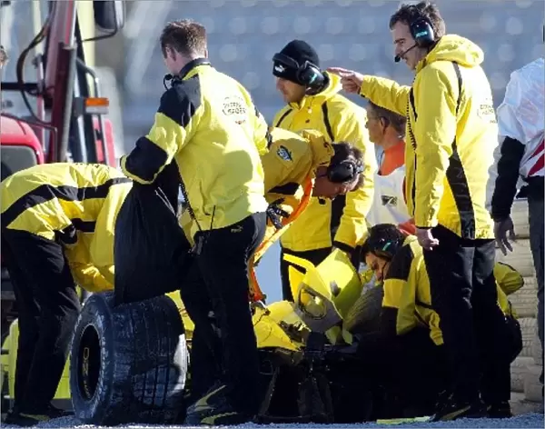 Formula One World Championship: The Jordan mechanics survey the damaged Jordan EJ12 after Giancarlo Fisichella suffered a big accident at the