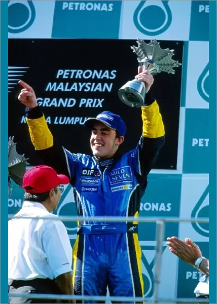 Formula One World Championship: Third placed Fernando Alonso Renault receives his and Spain├òs first podium trophy from Dr Mahathir Mohamad Malaysian