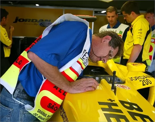Formula One World Championship: Scrutineers in the Jordan garage look at the EJ13