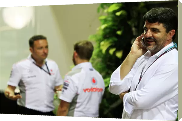 Marina Bay Circuit, Singapore. Friday 20th September 2013. Luis Garcia Abad, Manager of Fernando Alonso talks on a mobile phone near the McLaren team in the paddock. World Copyright: Charles Coates / LAT Photographic. ref: Digital Image _X5J8926