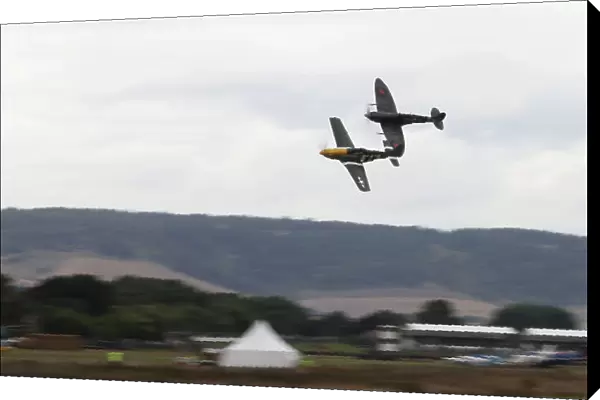 Goodwood Estate, West Sussex, England. 12th - 15th September 2013. P51 Mustang and Supermarine Spitfire fly low over the airfiled. Ref: IMG_3569a. World copyright: Kevin Wood / LAT Photographic
