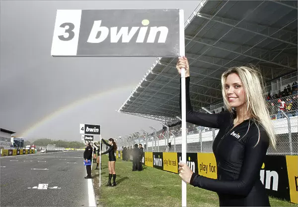MotoGP grid girls with a rainbow in the background.