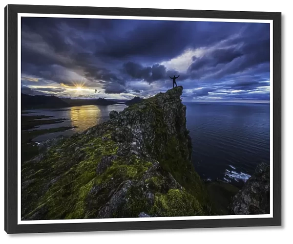 Man Standing On Top Of A Sea Cliff At Sunset Along Icelands Strandir Coast In The West Fjord Region; Iceland