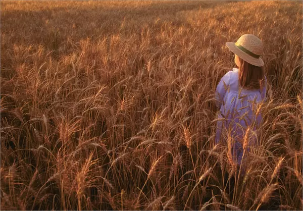 Girl with hat in field