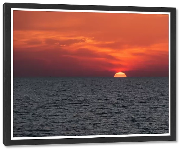 Dramatic Red Sky With The Sun Setting Under The Ocean And Horizon; Paphos, Cyprus