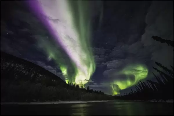 Colourful Northern Lights Glowing In The Night Sky Above A Lake And Forest; Yukon, Canada