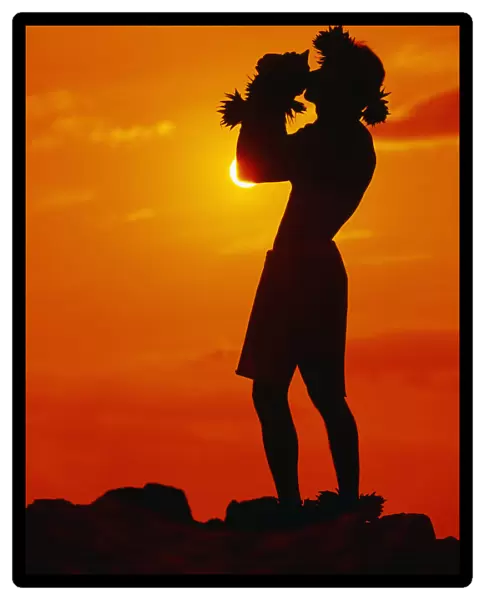 Hawaii, Maui, Napili, Silhouette Of Man Blowing Conch Shell At Sunset, Fiery Orange Sky