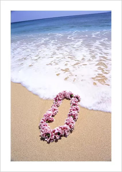 Close-Up Of Pink Lei In Sand On Beach, Foaming Shore Waters, Blue Sky