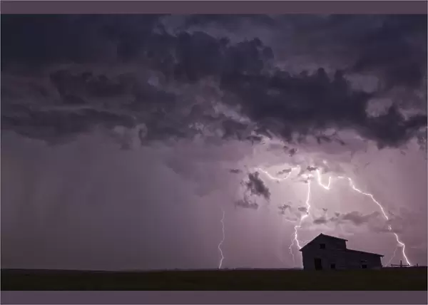 Lightning Strikes Over The Prairies As It Approaches An Old Abandoned Farm House; Val Marie, Saskatchewan, Canada