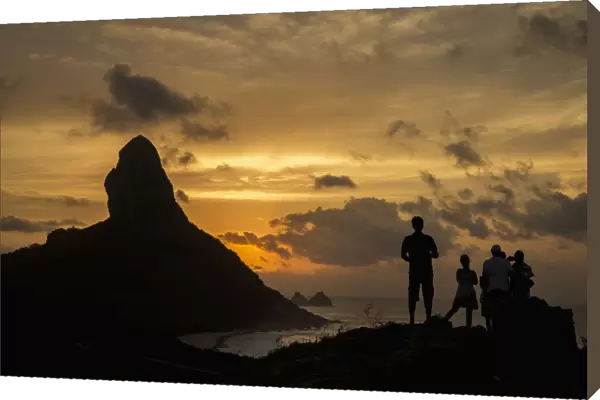 Brazil, Pernambuco, People admiring sunset over Morro do Pico from Forte dos Remedios; Fernando de Noronha