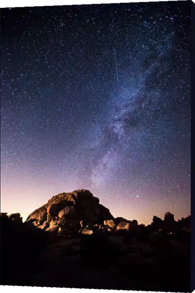 The Milky Way in starry night sky over a granite dome, Joshua Tree National Park, California, USA