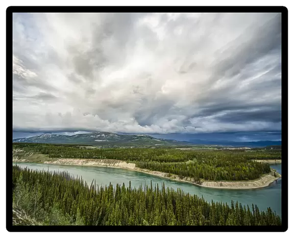 Yukon River with a storm passing overhead while flowing through Whitehorse; Whitehorse, Yukon, Canada