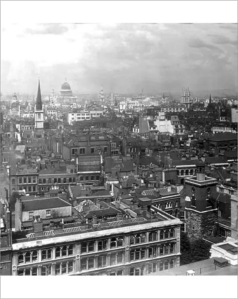 Historic image in black and white of a cityscape of London, England with St. Pauls Cathedral in the distance, circa 1920; London, England