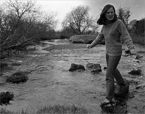 Bernadette Devlin MP for Mid Ulster walking on stepping stones across a river