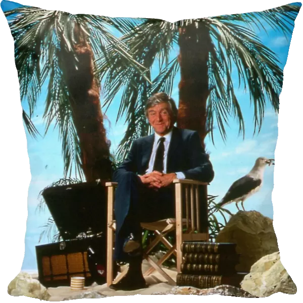 Michael Parkinson TV chat show presenter April 1986 sitting on a chair desert island palm