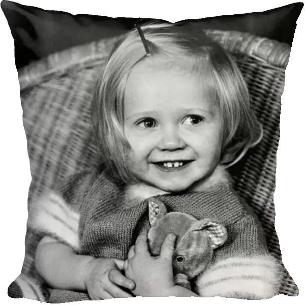 Young girl sitting in a wicker chair holding a teddy bear December 1969