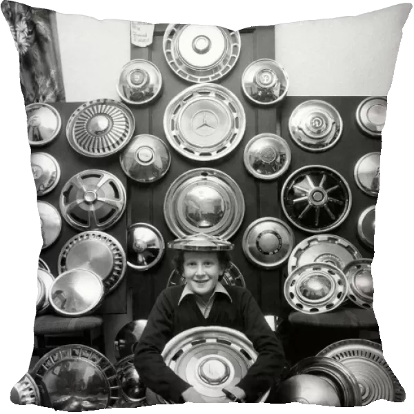 Young David and his collection of 130 caps. He collects hub caps that fly off care near