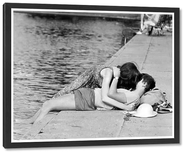 Love and Romance. A young couple oblivious to their surrounding seen here kissing beside