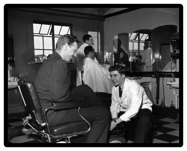 Terence O Neill at work as a shoe-shine boy in the barbers shop at the American Air