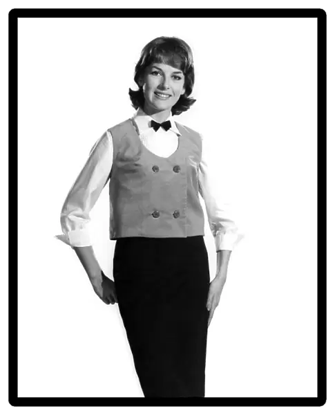 Model Diana Lovell wearing shirt bow tie and waistcoat with knee length skirt