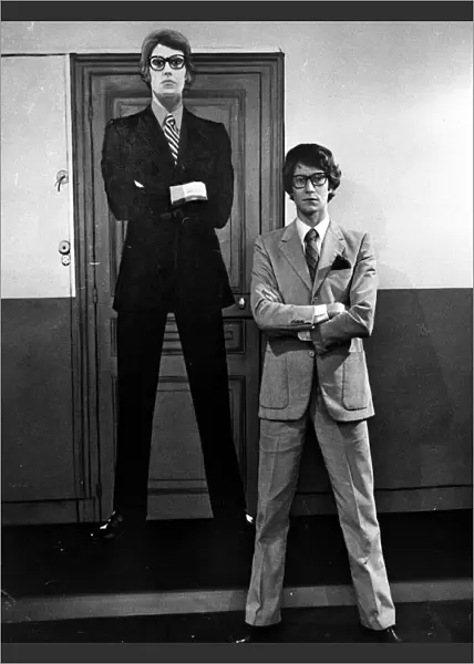 Yves Saint Laurent standing in front of a cardboard cartoon cut out of himself