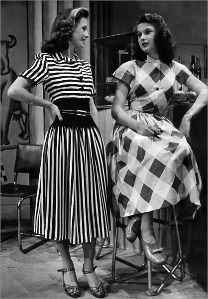 Audreywearing a brown and white striped dress. Rita in a big check pattern