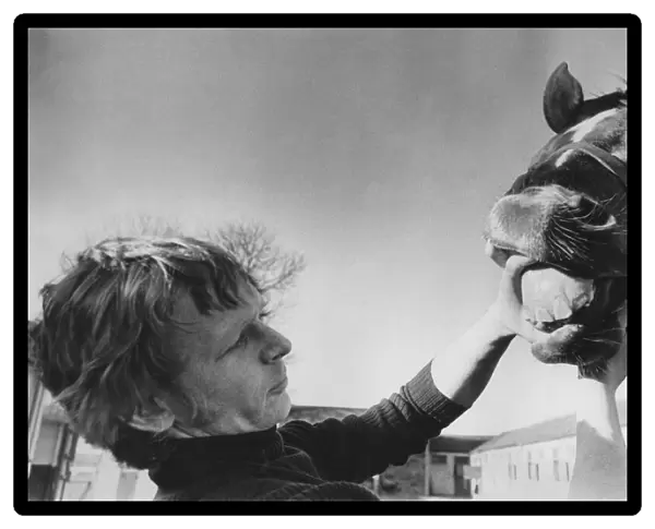 Jockey Gordon Holmes attending to teeth of a horse. September 1974 P007117