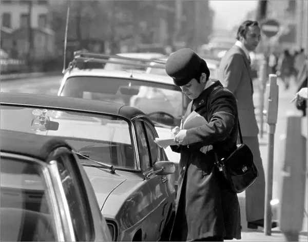 A traffic warden putting a ticket on a car without a tocket during her patrol