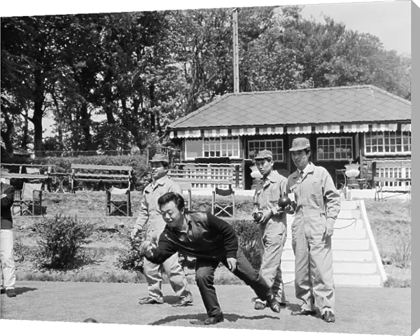 Japanese rider Shimazaki playing bowls with his team of mechanics watching
