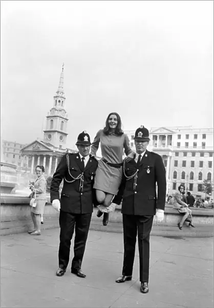 Woman being held up by two policemen in Trafalgar Square, London. October 1969 Z10351-001