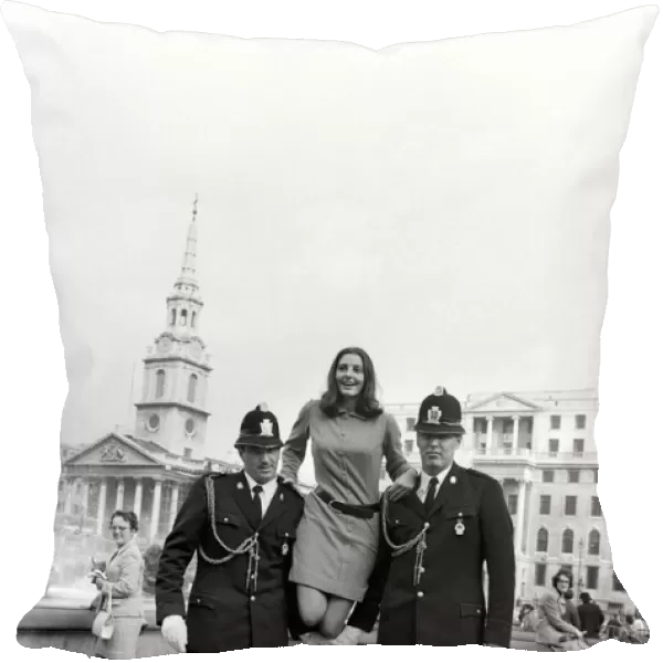 Woman being held up by two policemen in Trafalgar Square, London. October 1969 Z10351-001