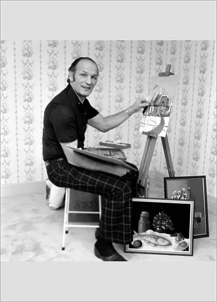 Henry Cooper working on a painting of a Cotswold Cottage. January 1977 77-00066-001