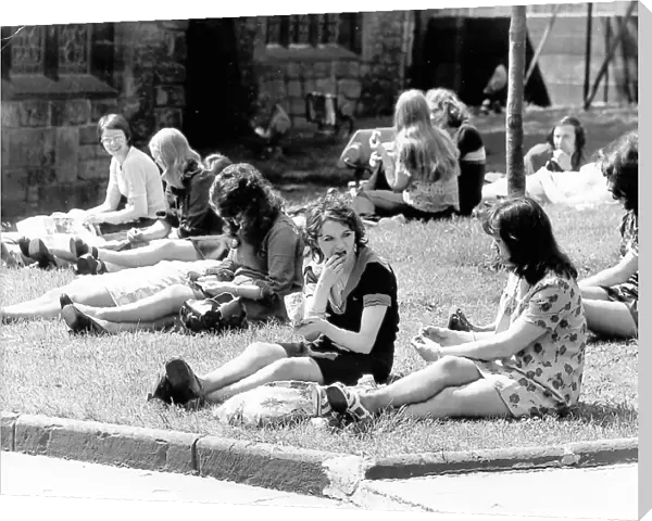 A group of young women enjoying the sun, on the grass at St
