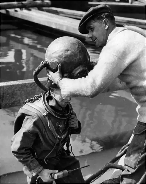 Diver Jack Ellis having his helmet put on. September 1949