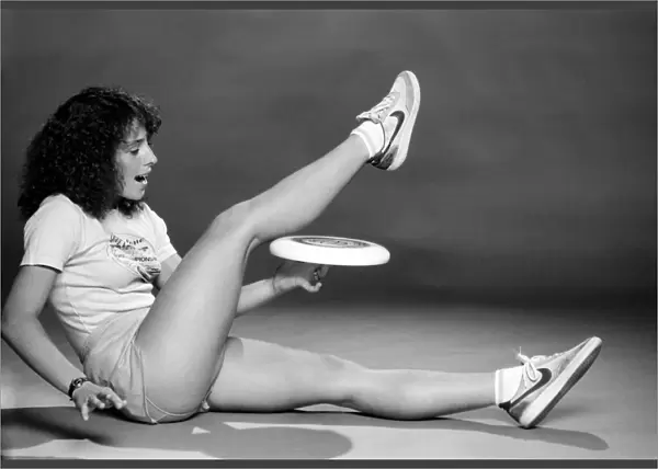 A woman performing exercises with a frisbee. June 1980