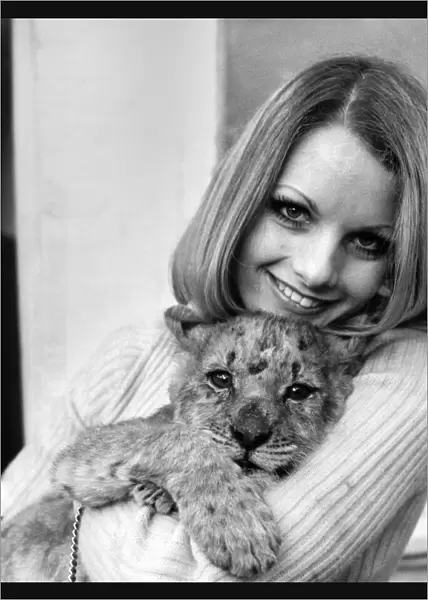 Former model Sally Bunting holding her lion cub pet at her home in Chiswick
