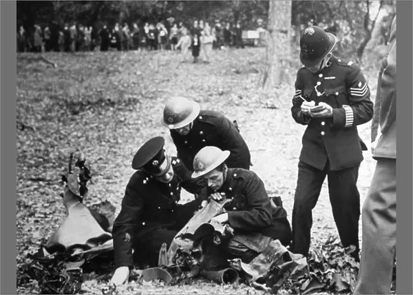 A fireman reading the wording on the remains of a bomb to a police officer who takes
