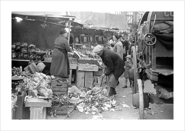 Council workers clear away the waste fruit and veg from around Kingston markets green