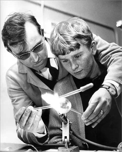 A scientific glass blower, Mr. Keith Hartley, instructs 17 year old Arthur Burdon in
