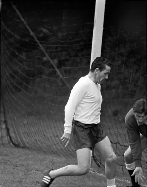 Members of the Tottenham Hotspur team training. Dave Mackay practices his tackling