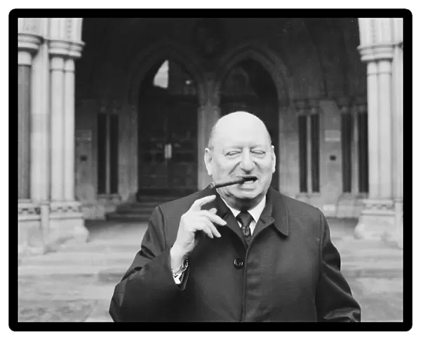Media Mogul Lew Grade poses outside the High Court in London, smoking one of his cigars